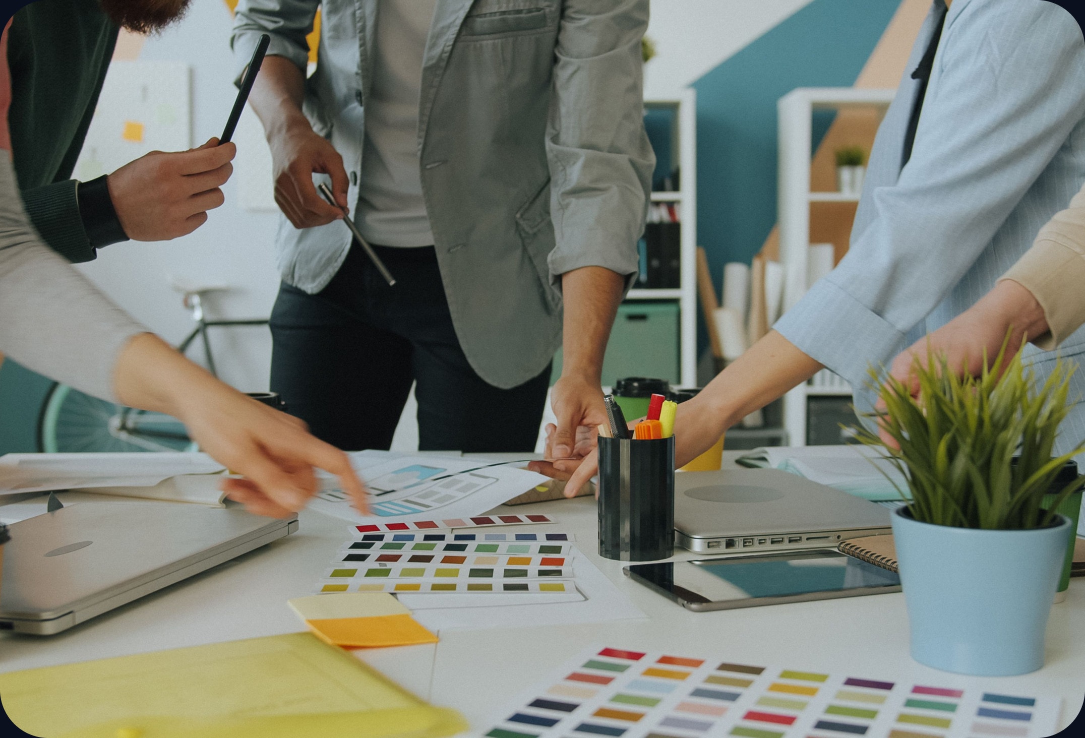 A team planning over printed layouts and colour swatches